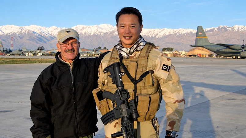 Nick Tran in U.S. Army uniform beside a fellow service member on an airfield.